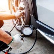 Mechanic performing tyre pressure checking on a car by CarStreet2u – car maintenance tip