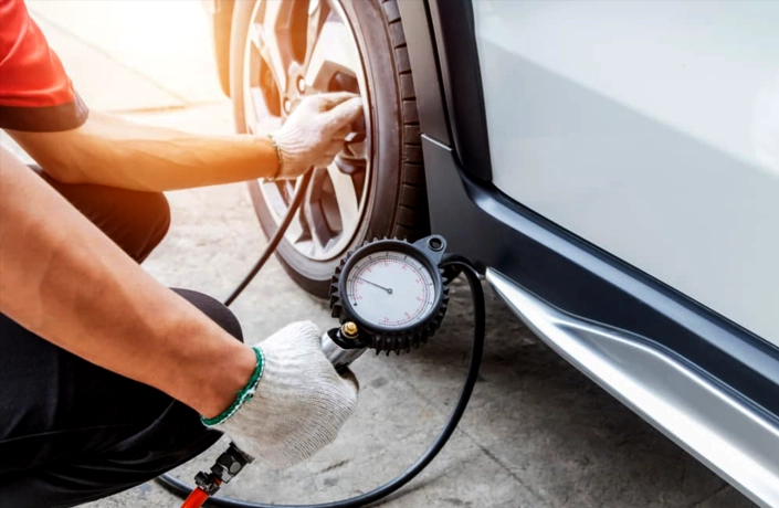 Mechanic performing tyre pressure checking on a car by CarStreet2u – car maintenance tip