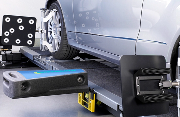 Mechanic performing wheel alignment on a car at worskhop by CarStreet2u – car maintenance tip